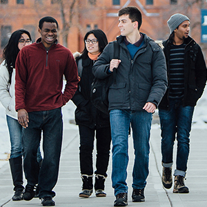 Group of students walking in front of Montana Hall in winter.