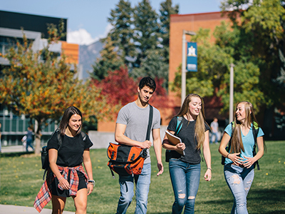 A group of students walk on campus in fall.