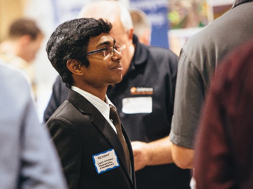 Engineering student speaking with a group of recruiters