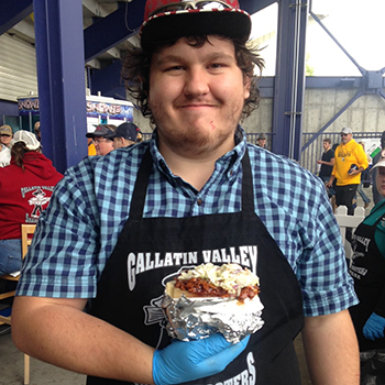 Student employee working concessions holding burger