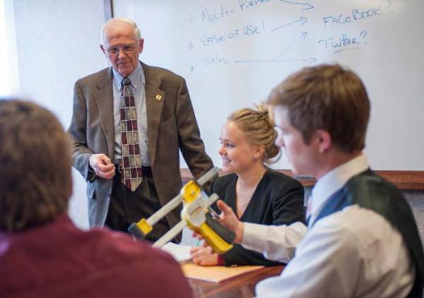 Photo of student team and professor working on a client challenge