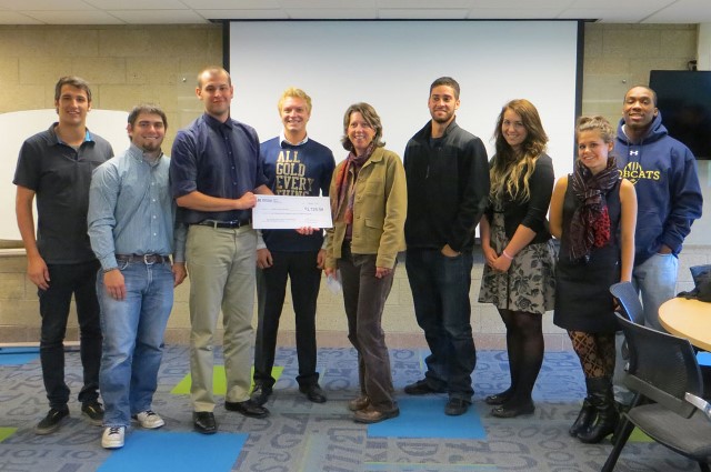 Eight students present a check to a person from the Gallatin Valley Fook Bank