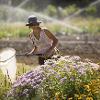 Woman holding large mesh net near purple and yellow flowers - Photo by Kelly Gorham