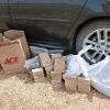 Plastic and paper bags lying on the ground next to a car