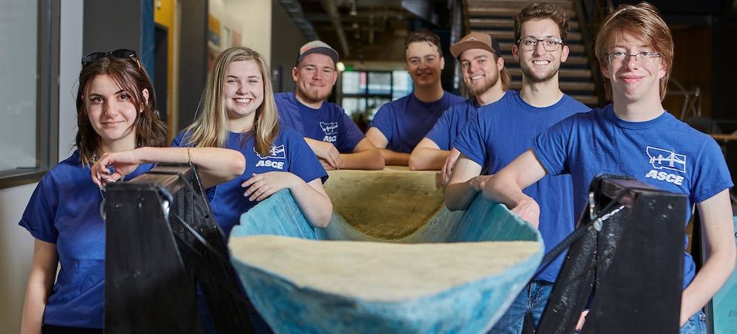 Photo of concrete canoe team posing with canoe.