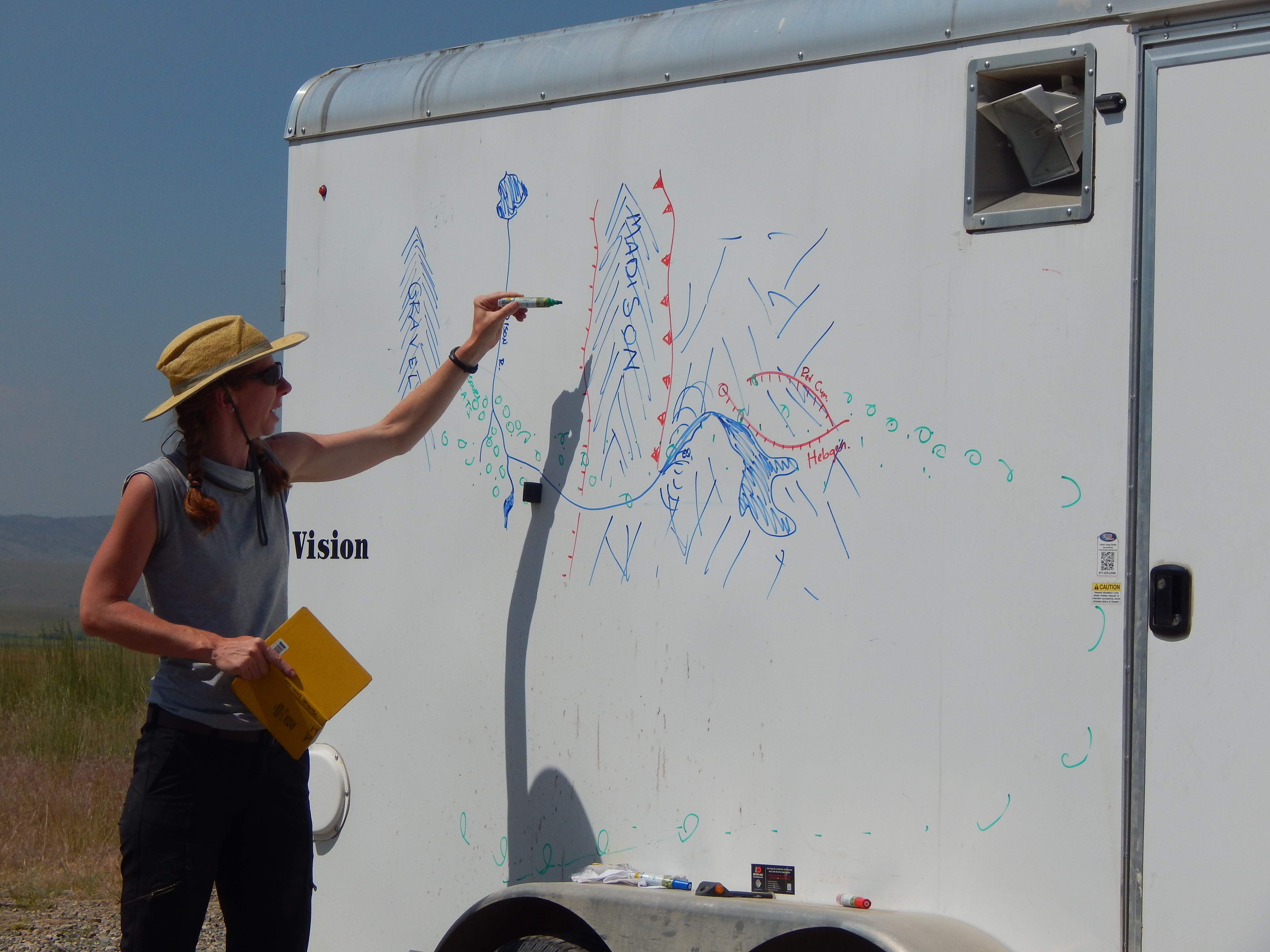 Dr. Jean Dixon delivering a lecture in the field using a trailer as a white board