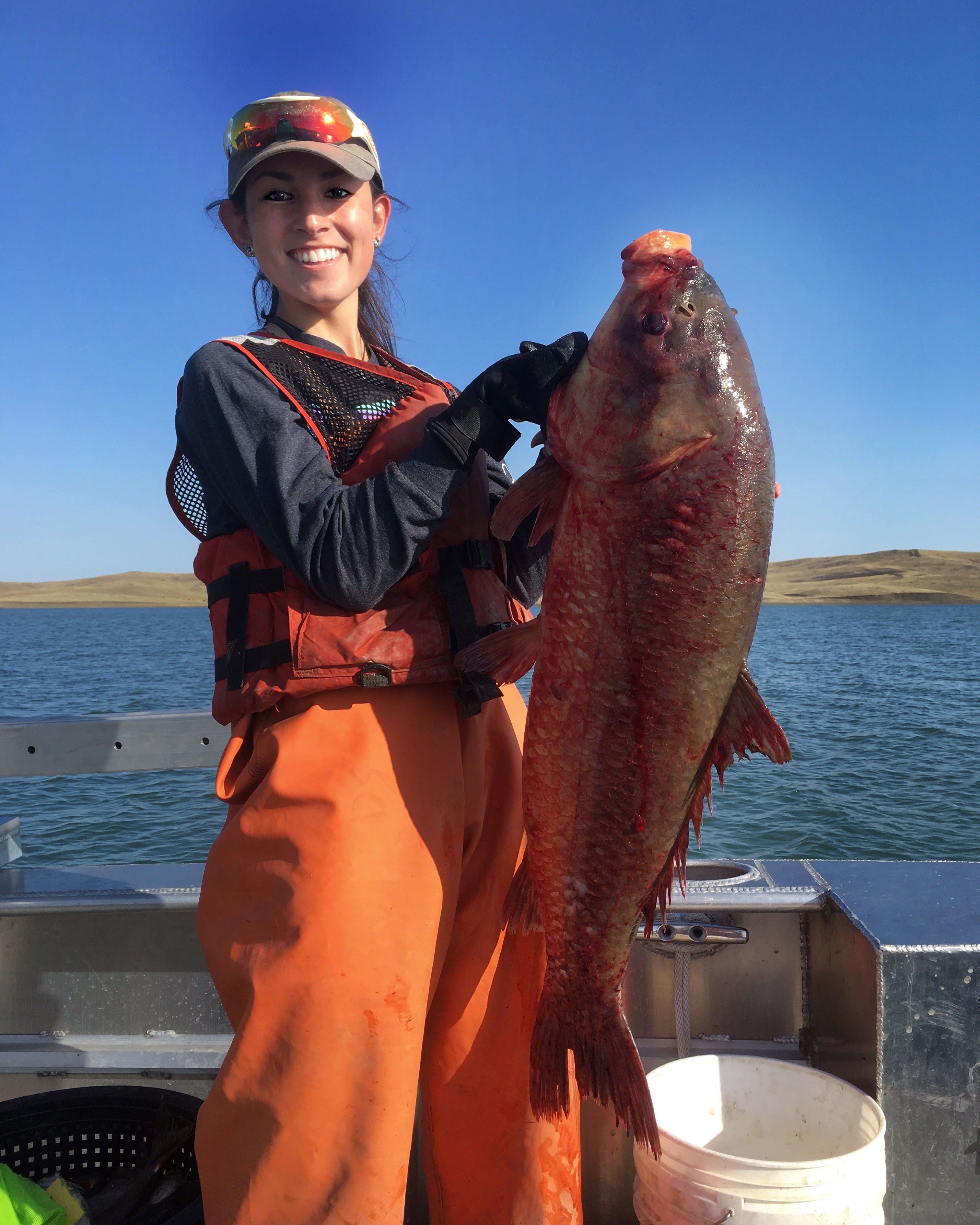 Matea holds fish on boat in water