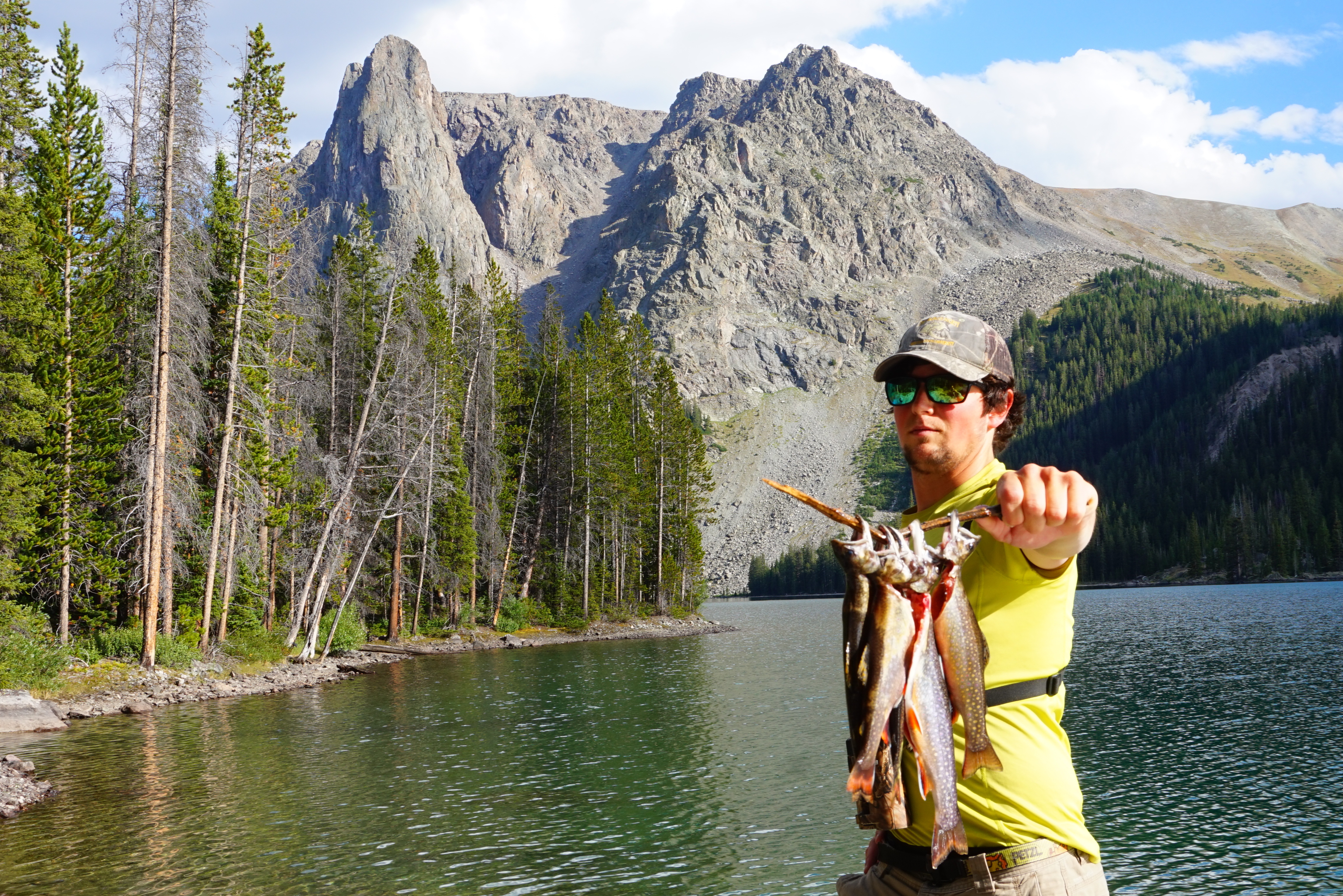 James holding fish on alpine lake