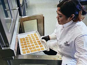 Sharon Li removes a batch of lentil crackers from the oven