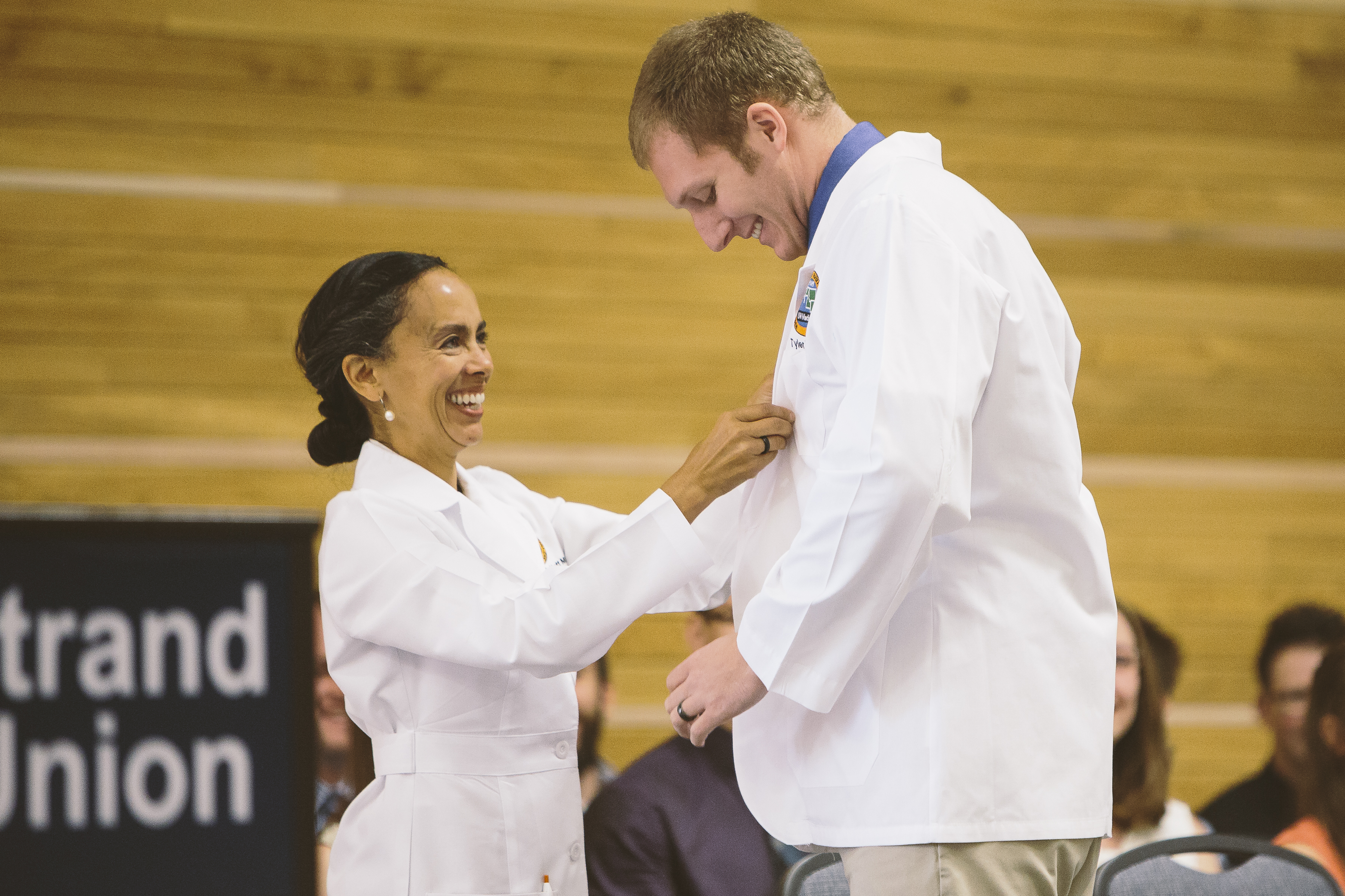 student receiving WAMI white coat at ceremony