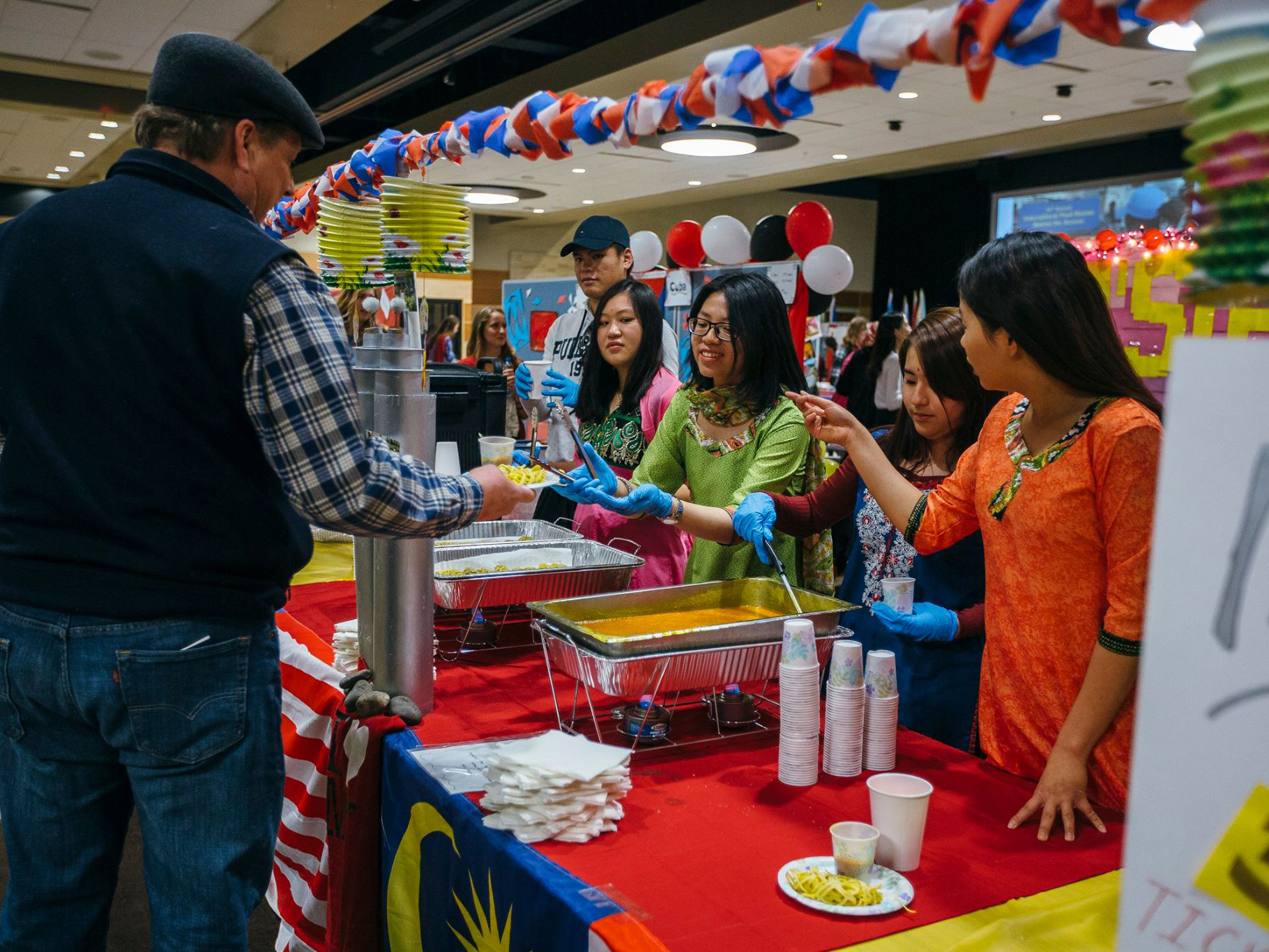 Students serving food at 34th Annual Interntional Food Bazaar