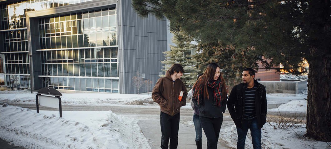 Four international students walking in front of Jake Jabs Hall