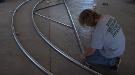 A worker assembling hoops for the high tunnel