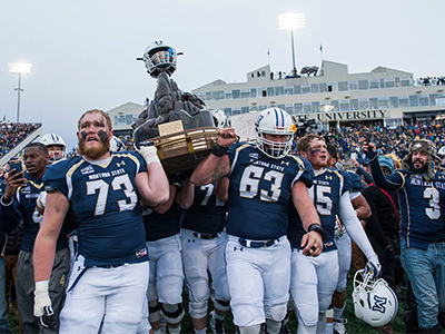MSU football players carrying the Great Divide trophy after winning the 2017 Brawl of the Wild vs. U Montana