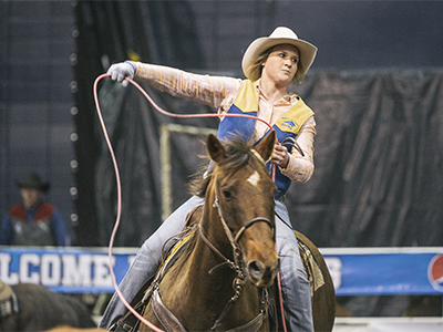 Female rider lassoing at rodeo