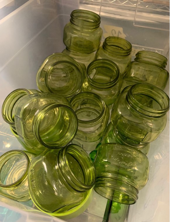 Bin of green glass decorative pint jars