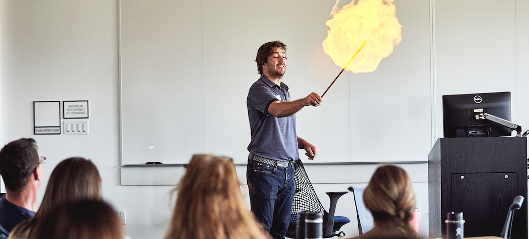 ball of flame as man ignites small balloon of flamable substance in exciting demonstration for k-12 teachers