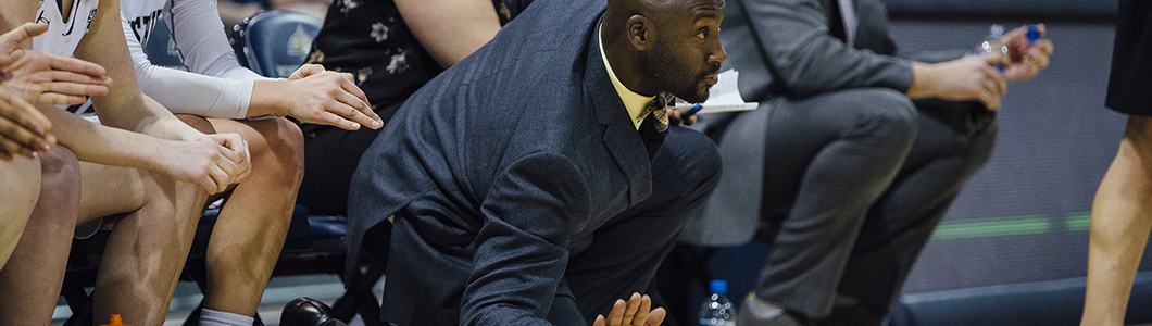 Coach watches team from sidelines