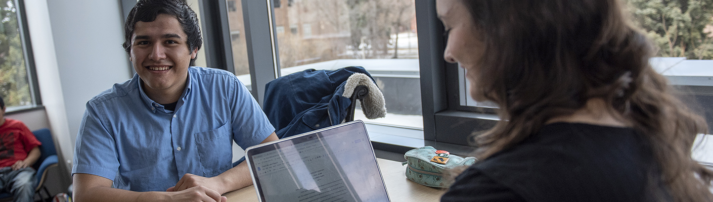 Two students discuss a project over a desk in the Empower Center on the Bozeman campus.