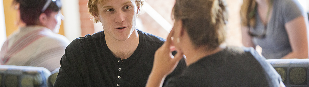 A young man and a young woman hold a discussion.