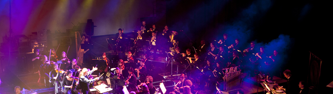 An orchestral ensemble sits on stage.