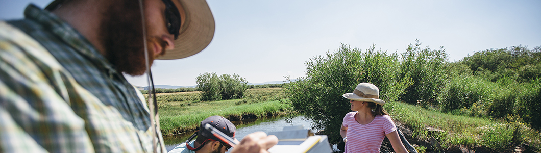 Researchers work next to a river