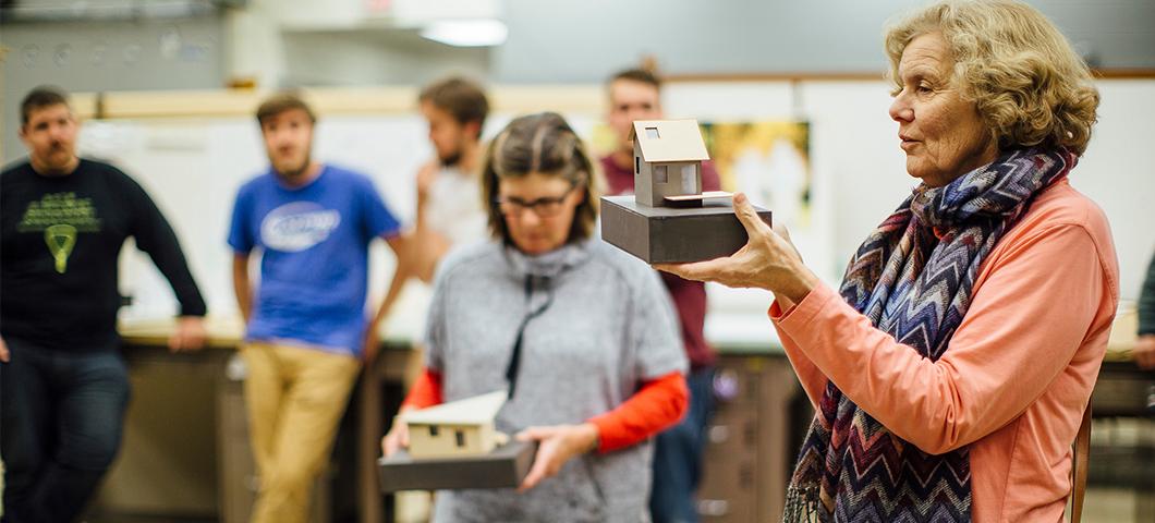 Professors critique projects in a studio.