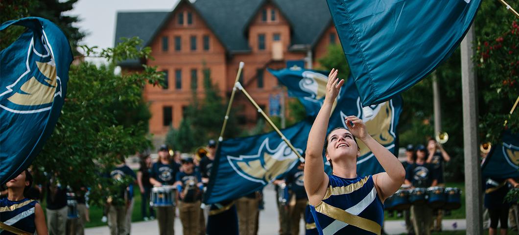 The Spirit of the West Color Guard throws flags in front of Montana Hall.