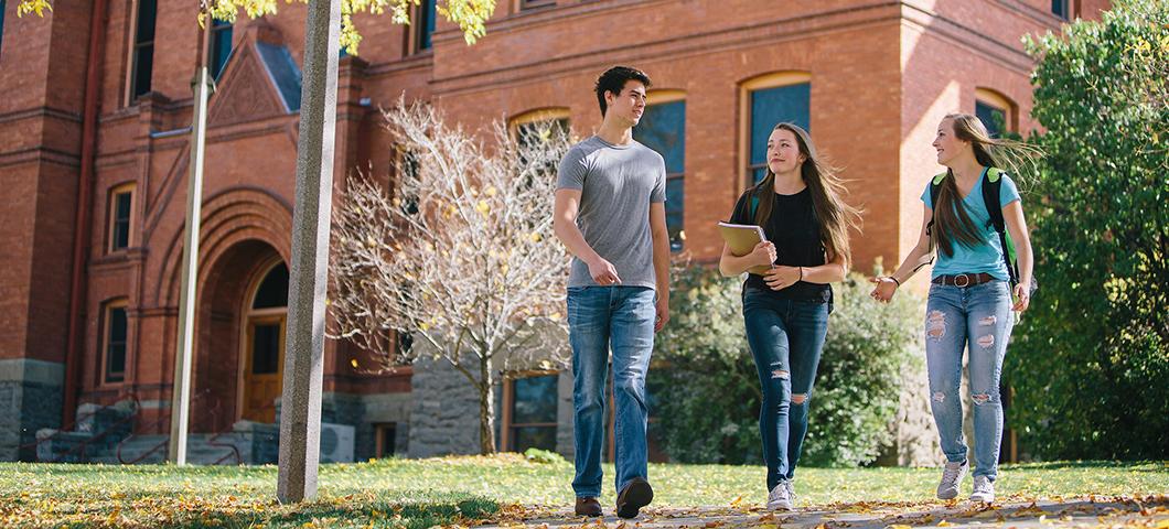Three students walk on campus