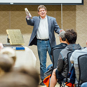 A professor speaks to a class on campus.