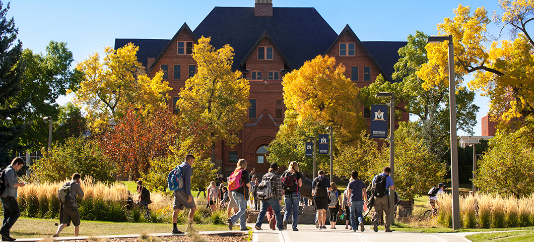 Students walking in front of Montana Hall in fall.