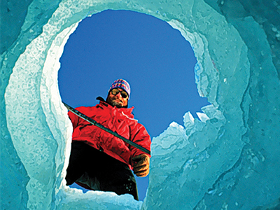 A researcher looks down an ice tunnel.