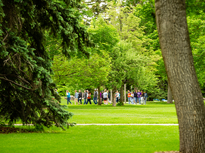 A tour crosses campus in summer.