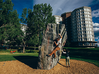Student practices bouldering outside of Roskie residence hall
