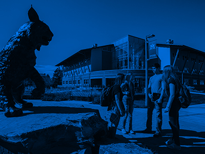 A group of students stand in Alumni Plaza