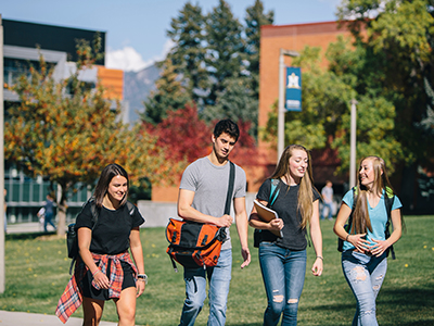 Four students walk across campus.