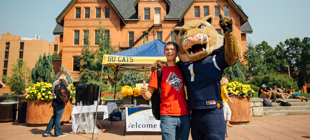 Student standing with Champ on Centennial Mallhall