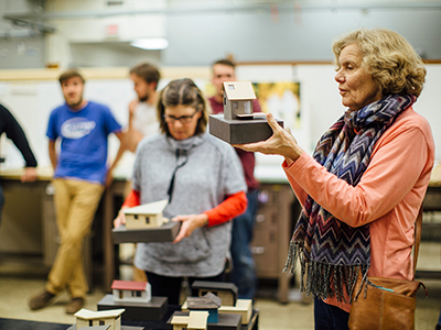 Faculty members looking at student projects