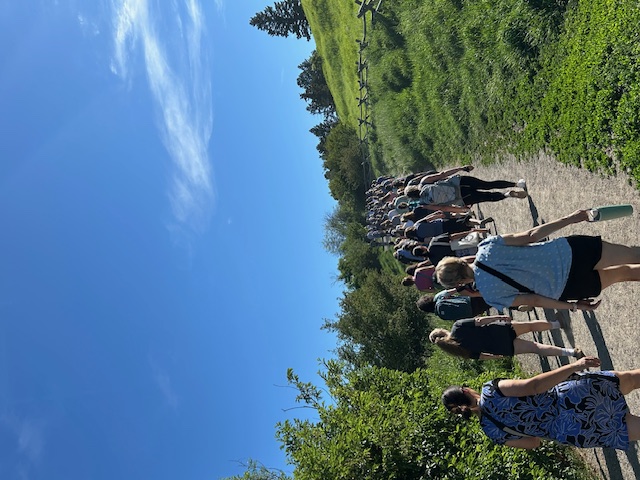Several people walking on a wide dirt path at Peet's Hill