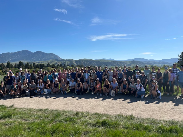A large group of people outdoors in front of mountains