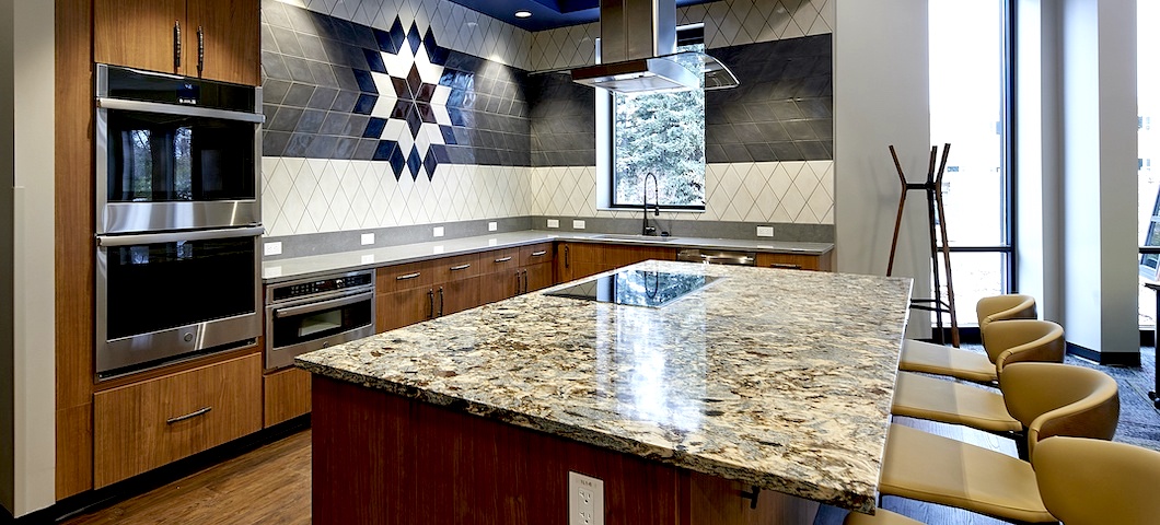 A kitchen with rock countertops gleams under the lights of the student commons in MSU's American Indian Hall.