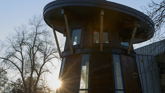 Morning light gleams beyond the exterior of American Indian Hall's drum room.