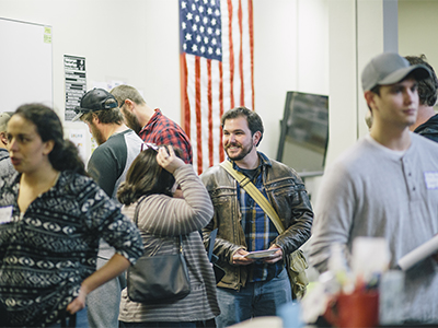 Student veterans converse with job recruiters from engineering corporations in the MSU veterans center