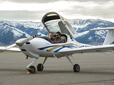 Gallatin College student and instructor sit in airplane cockpit