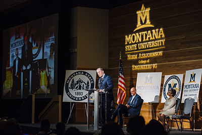 Norm Asbjornson speaks at a podium in the SUB ballrooms