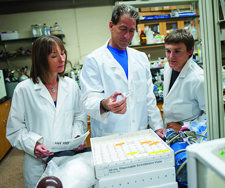 MSU professor and polar ecologist John Priscu, center, inspects samples from subglacial Antarctica in his lab