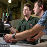 Two people looking through a microscope in a lab