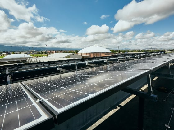 Solar panels on the roof of a building with a mountainous horizon in the background. | MSU