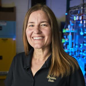 Portrait of Stephanie Wettstein in a lab looking at the camera and smiling.