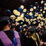 Hundreds of balloons fall atop college students in graduation gowns at Montana State University's fall 2021 commencement ceremony. 